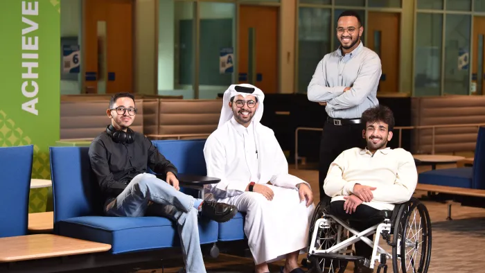 Group of 4 university students posing for a photo