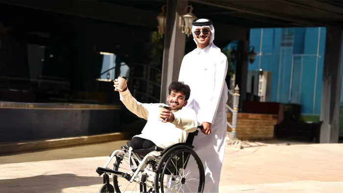student in wheelchair cherishing success with his university fellow